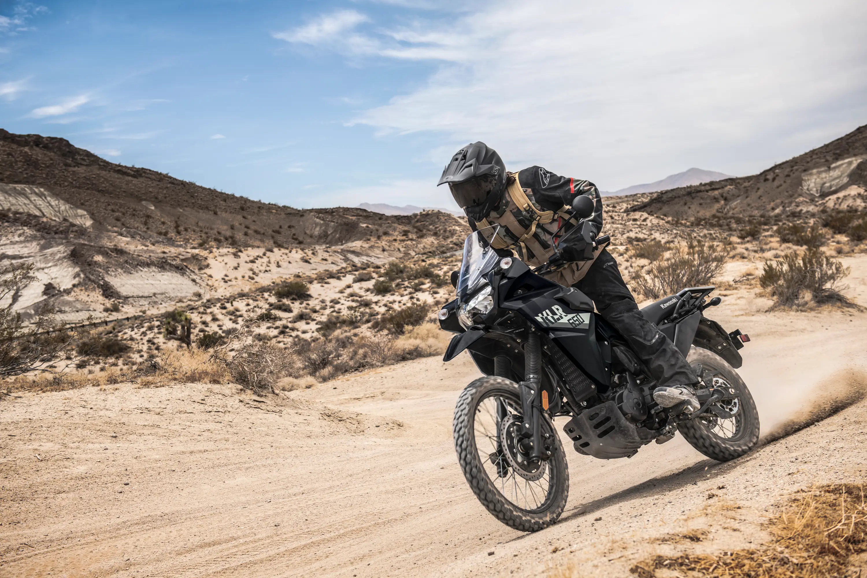 Three-quarter front angle of a person riding a motorcycle off-road.