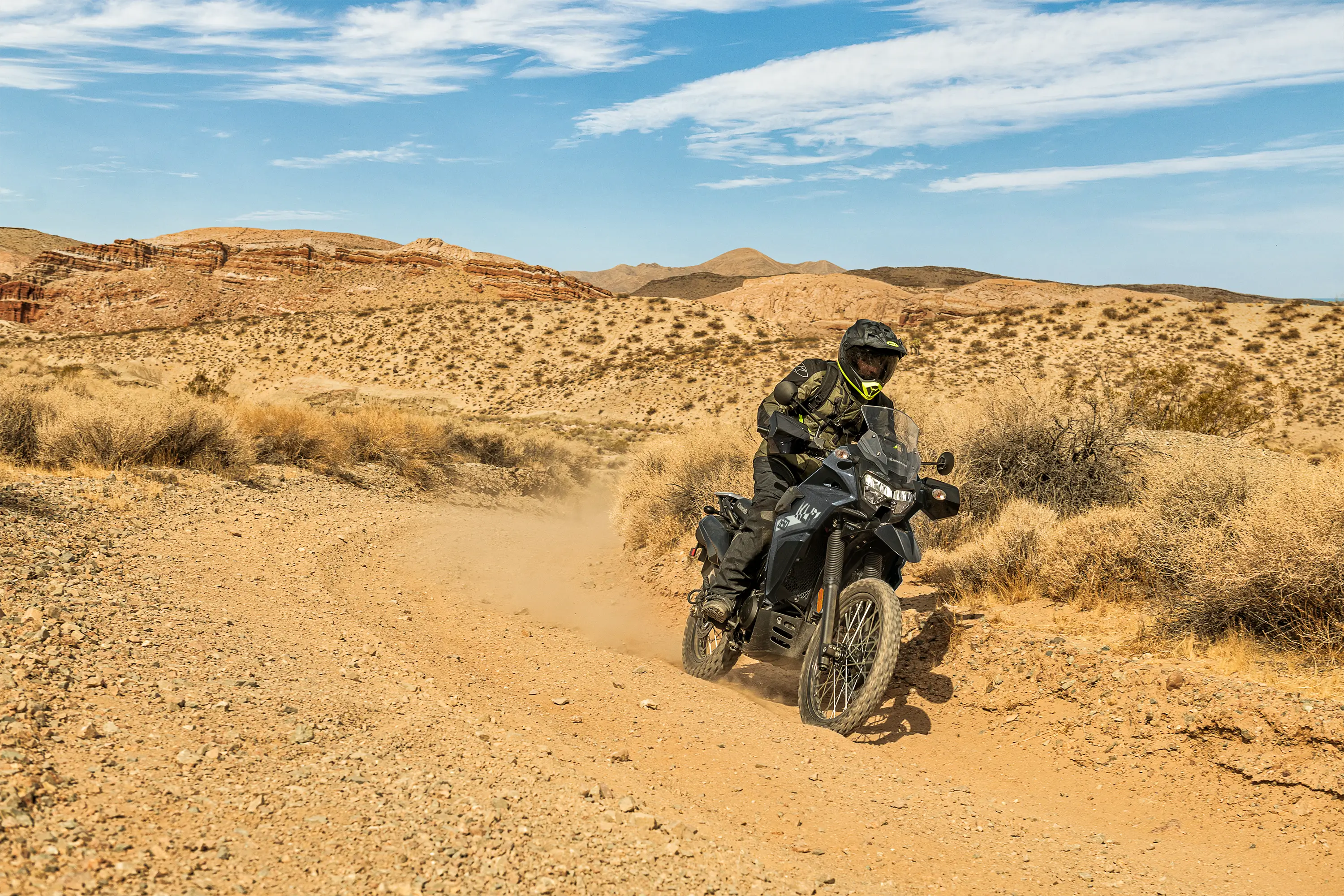 Three-quarter front angle of a person riding a motorcycle around a corner off-road.