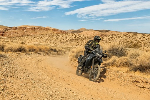 Three-quarter front angle of a person riding a motorcycle around a corner off-road. opens in a new window