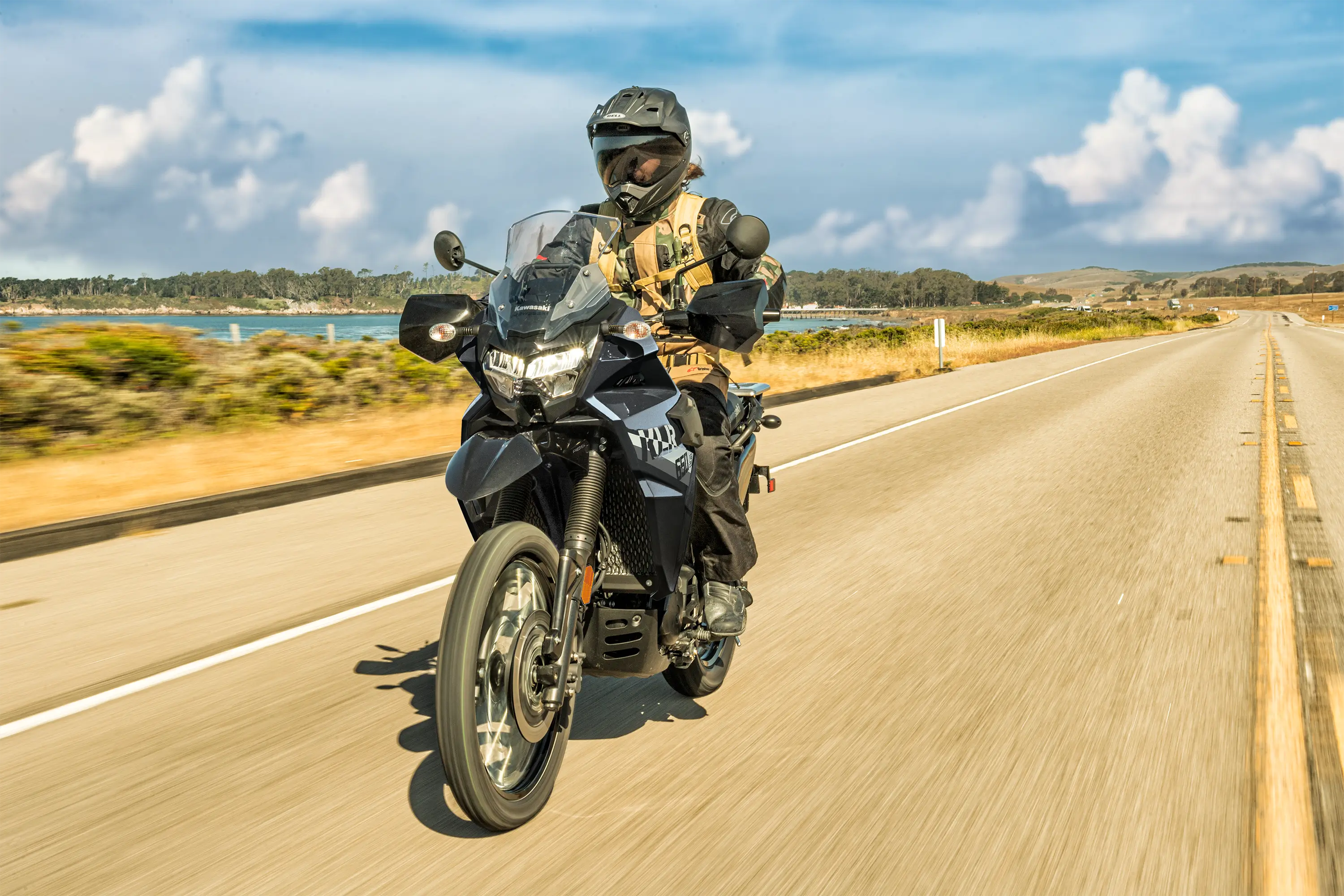Three-quarter front angle of a person riding a motorcycle on a highway.