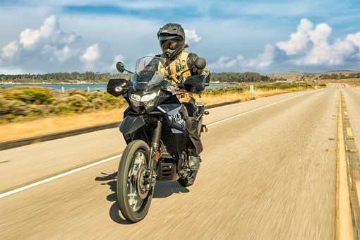Three-quarter front angle of a person riding a motorcycle on a highway. opens in a new window