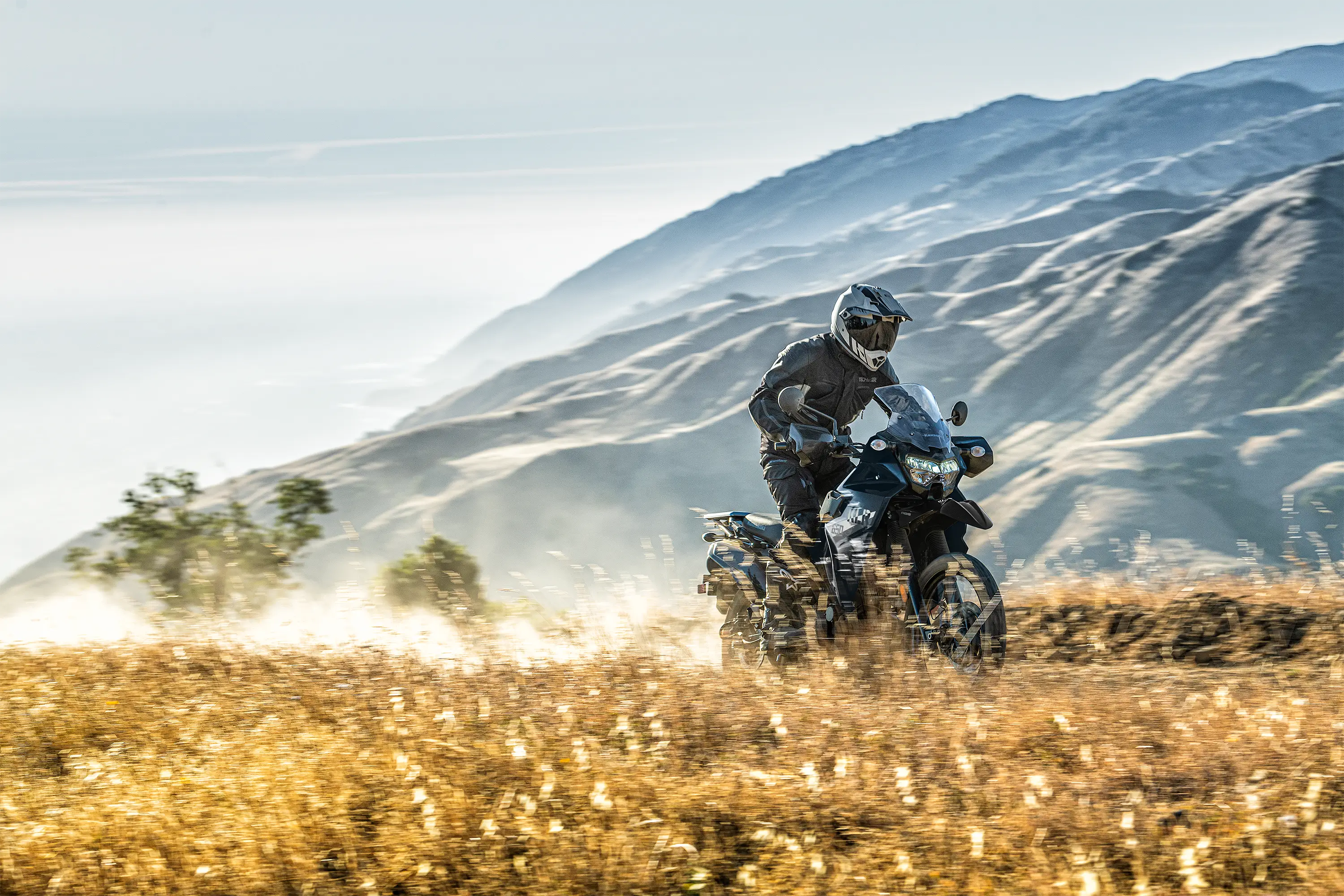 Three-quarter front low down angle of a person riding a motorcycle off-road.