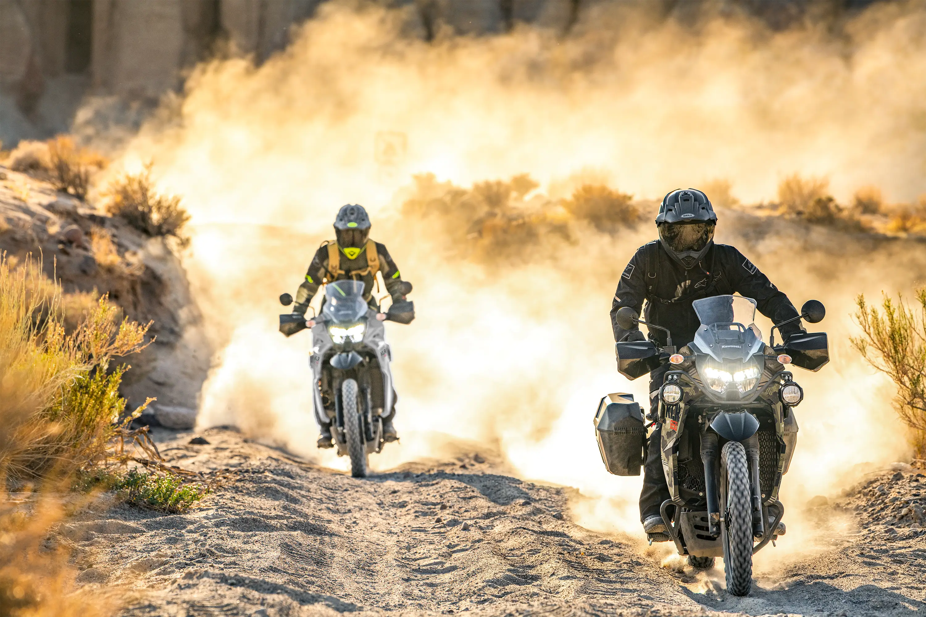 Front angle of two people riding a motorcycles off-road.