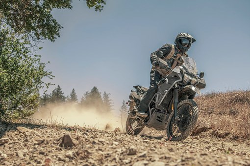 Three-quarter front angle up close of a person riding a motorcycle off-road. opens in a new window