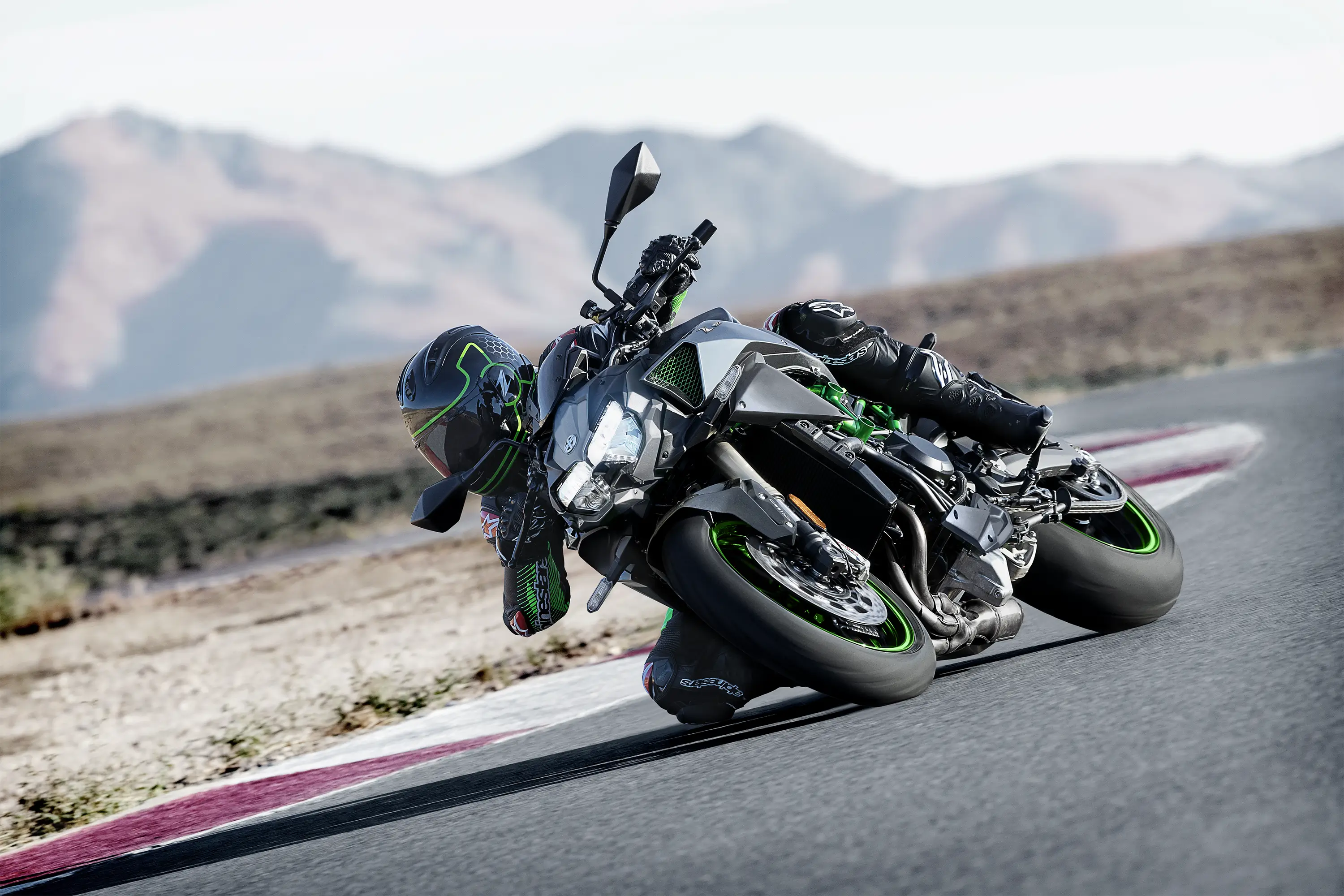Three-quarter front angle of a person riding a motorcycle on a track.
