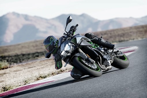 Three-quarter front angle of a person riding a motorcycle on a track. opens in a new window