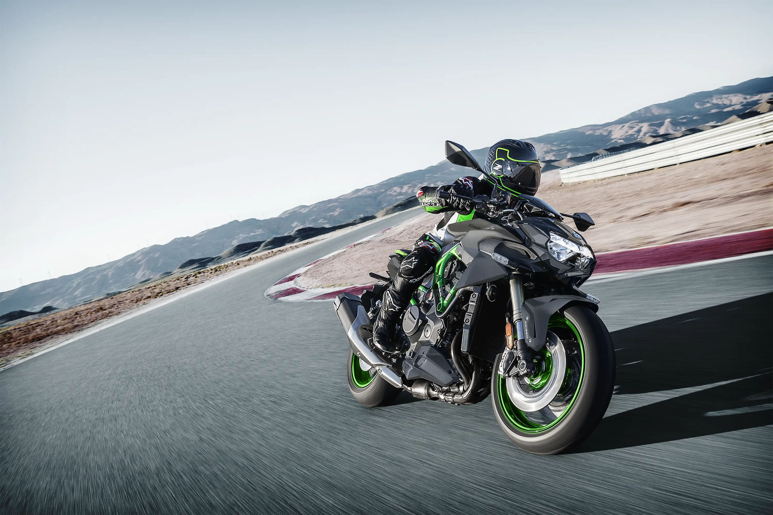Front three-quarter angle of a person riding a motorcycle turning on a track.