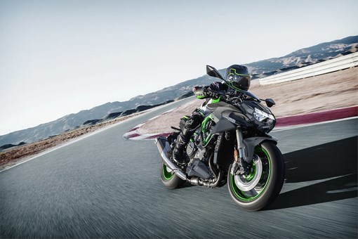 Front three-quarter angle of a person riding a motorcycle turning on a track. opens in a new window