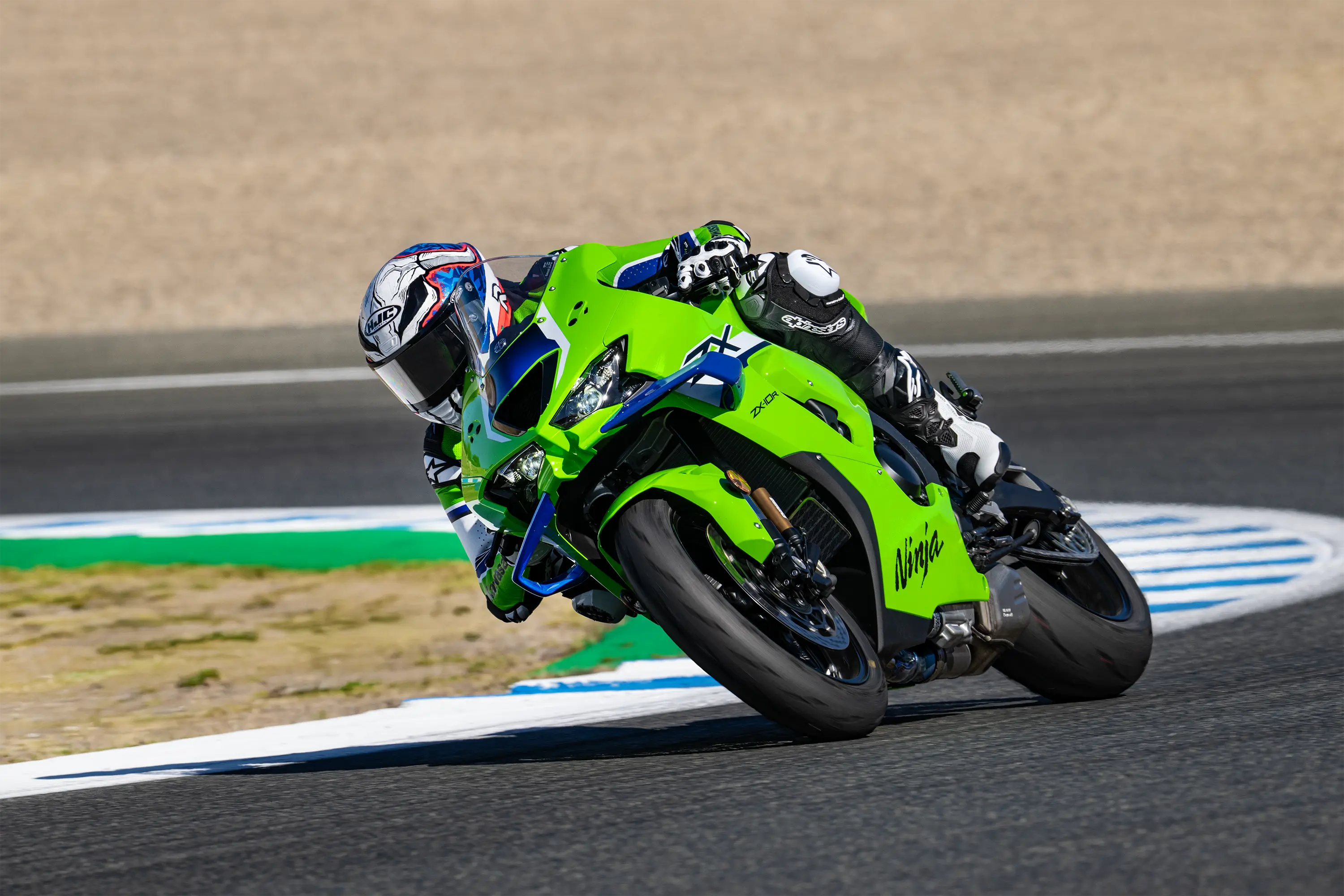 Three-quarter front angle of a person riding a motorcycle turning on a racetrack.