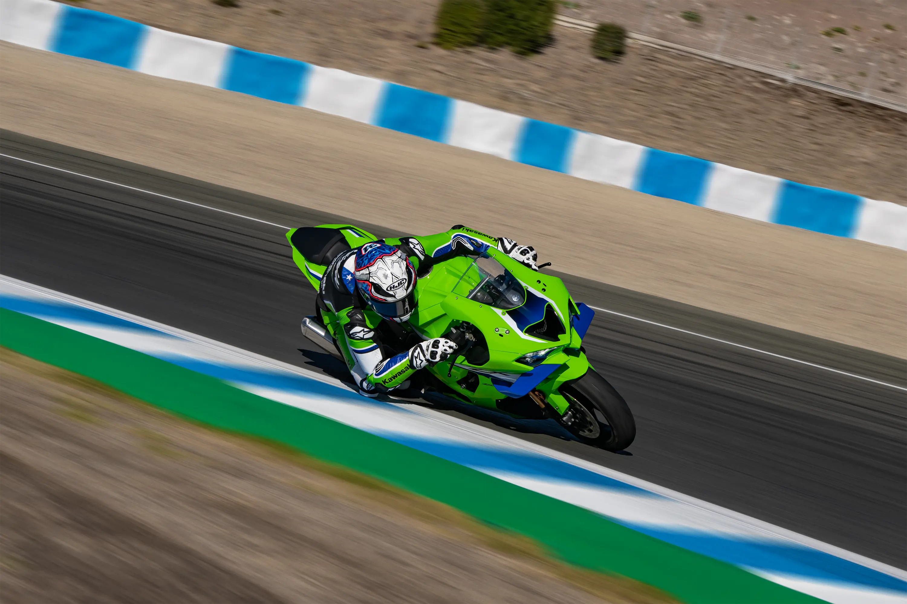 front angle of a person riding a motorcycle turning on a racetrack.