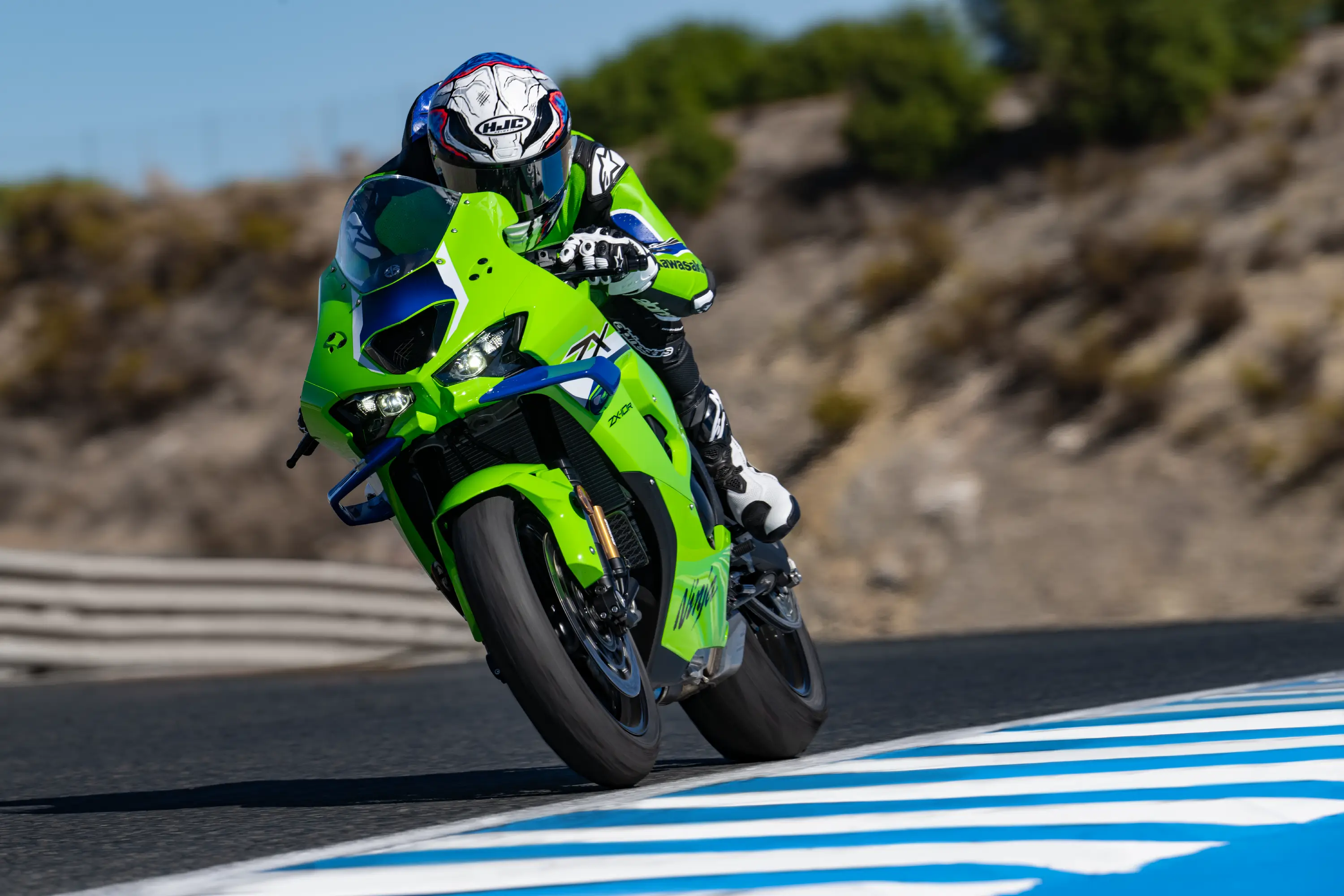 Three-quarter front angle of a person riding a motorcycle on a racetrack.