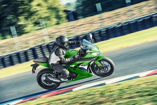 Side angle of a person riding a motorcycle on a track. opens in a new window