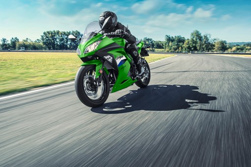 Three-quarter front angle of a person riding a motorcycle on a track. opens in a new window