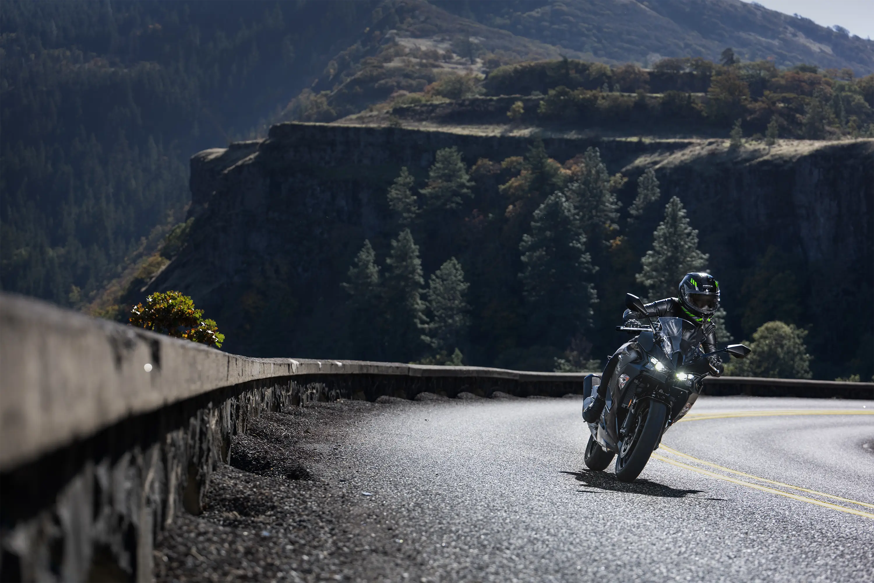Front angle of a person riding a motorcycle on a road.