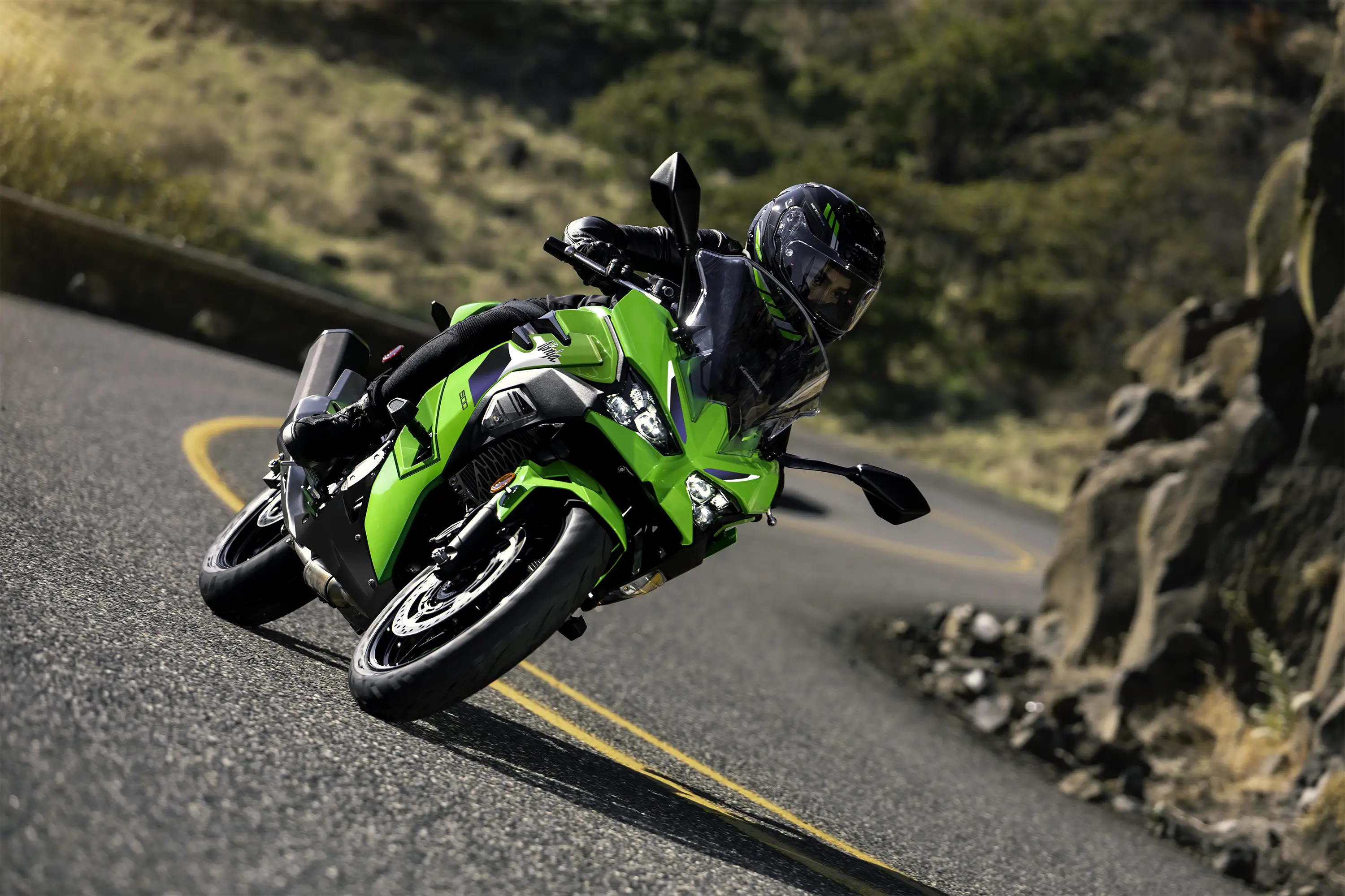 Front angle of a person riding a motorcycle on a road.