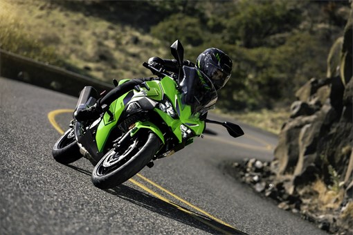 Front angle of a person riding a motorcycle on a road. opens in a new window