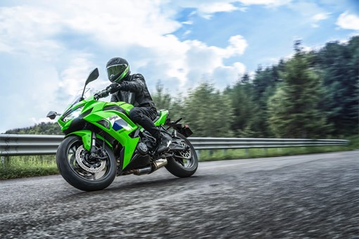 Low front three-quarter angle of a person riding a motorcycle on a highway. opens in a new window