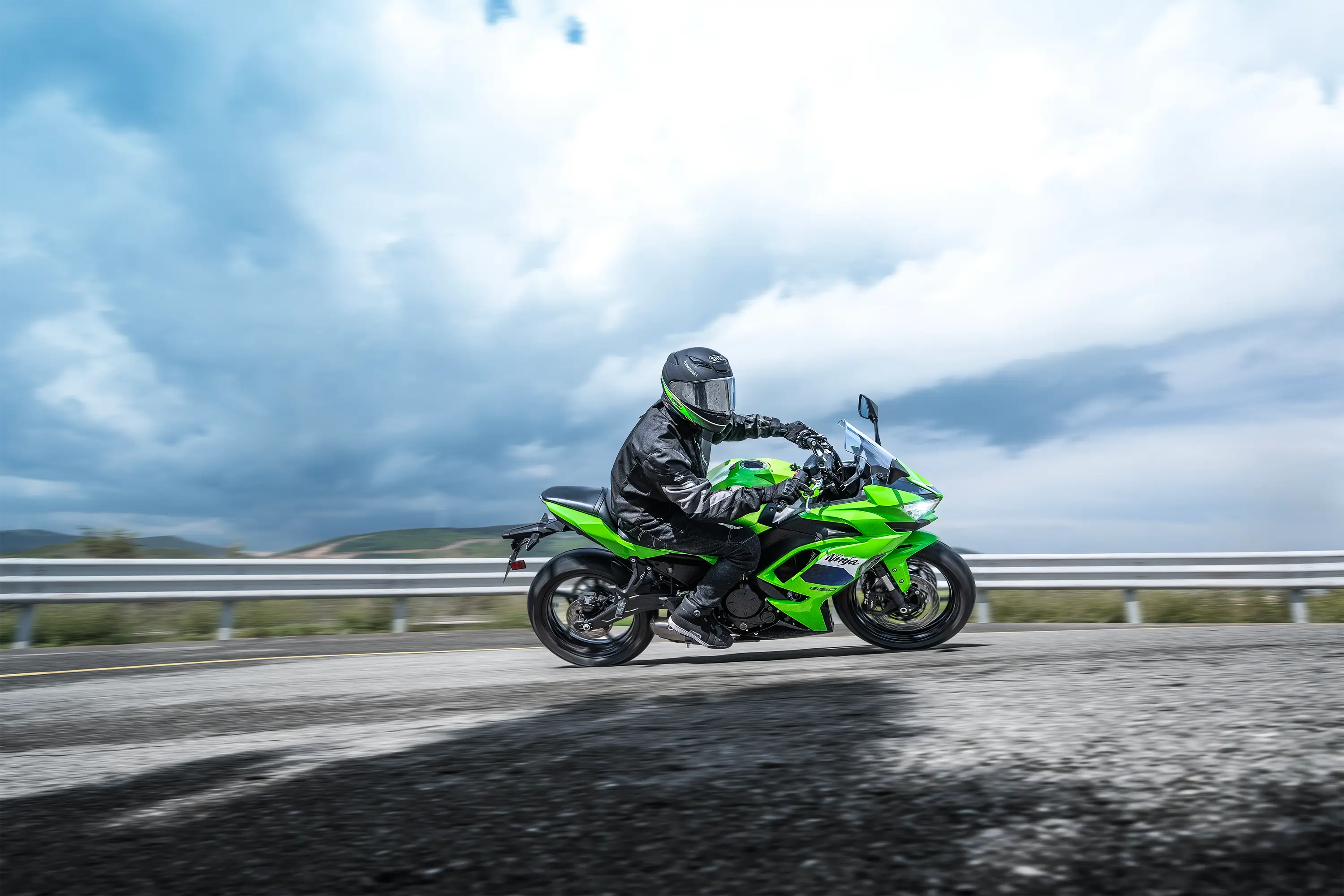 Side angle of a person riding a motorcycle on a highway.