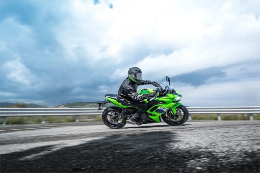 Side angle of a person riding a motorcycle on a highway. opens in a new window