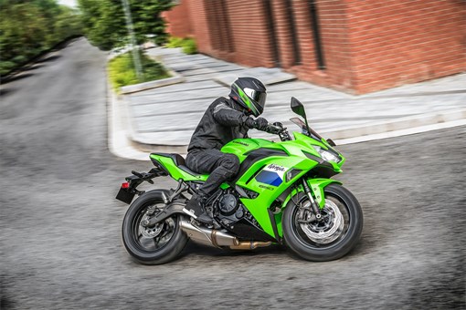 Side angle of a person riding a motorcycle on the street. opens in a new window