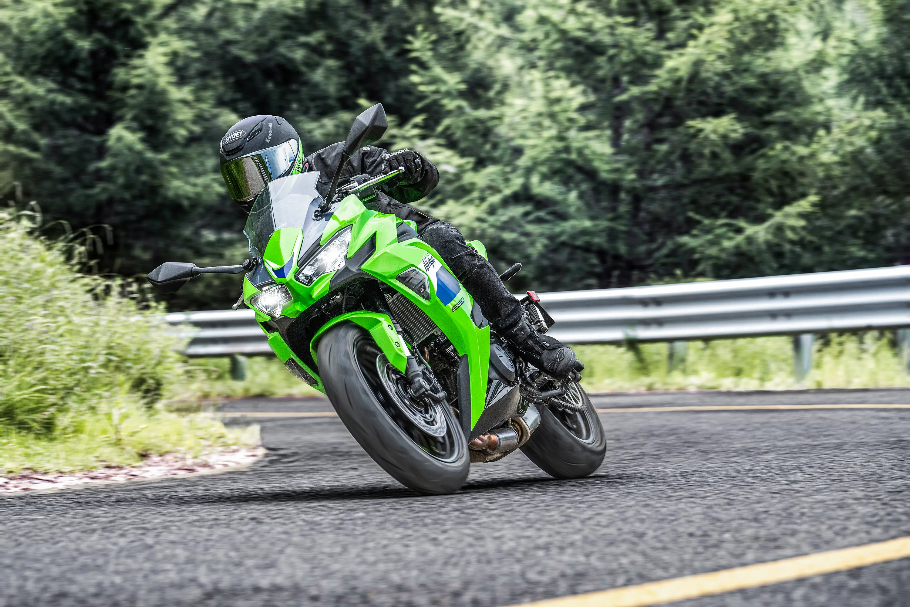 Three-quarter front angle of a person riding a motorcycle on a highway.