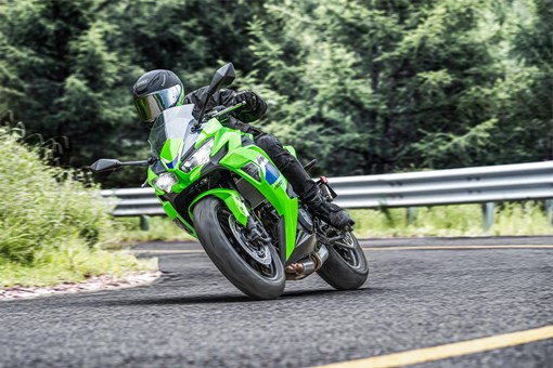 Three-quarter front angle of a person riding a motorcycle on a highway. opens in a new window