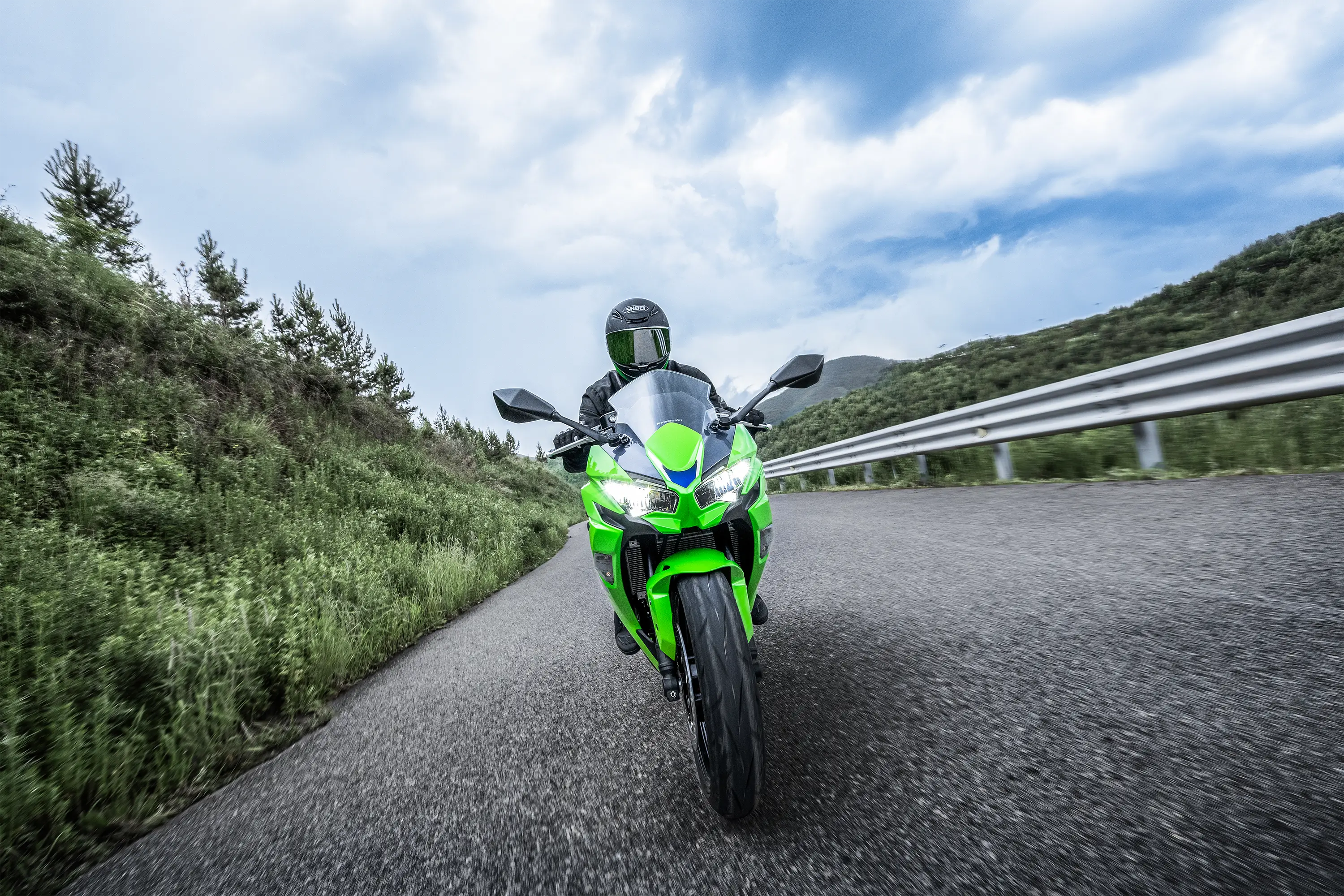Front angle of a person riding a motorcycle on a highway.
