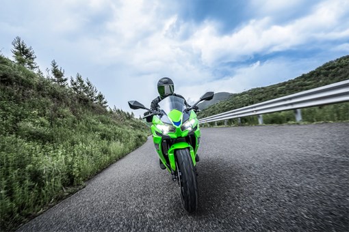 Front angle of a person riding a motorcycle on a highway. opens in a new window