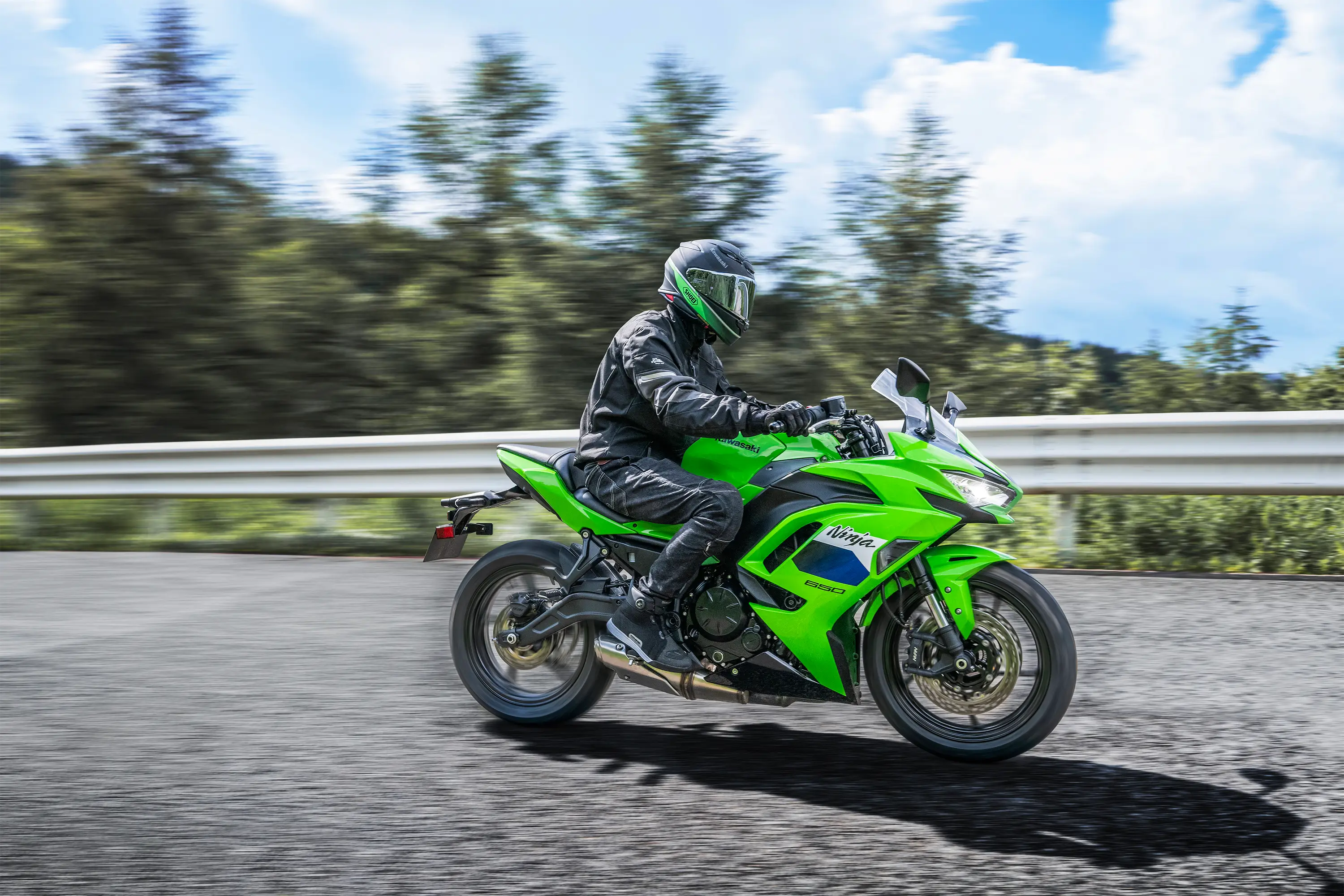 Profile angle of a person riding a motorcycle on a highway.