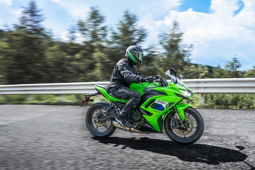 Profile angle of a person riding a motorcycle on a highway. opens in a new window