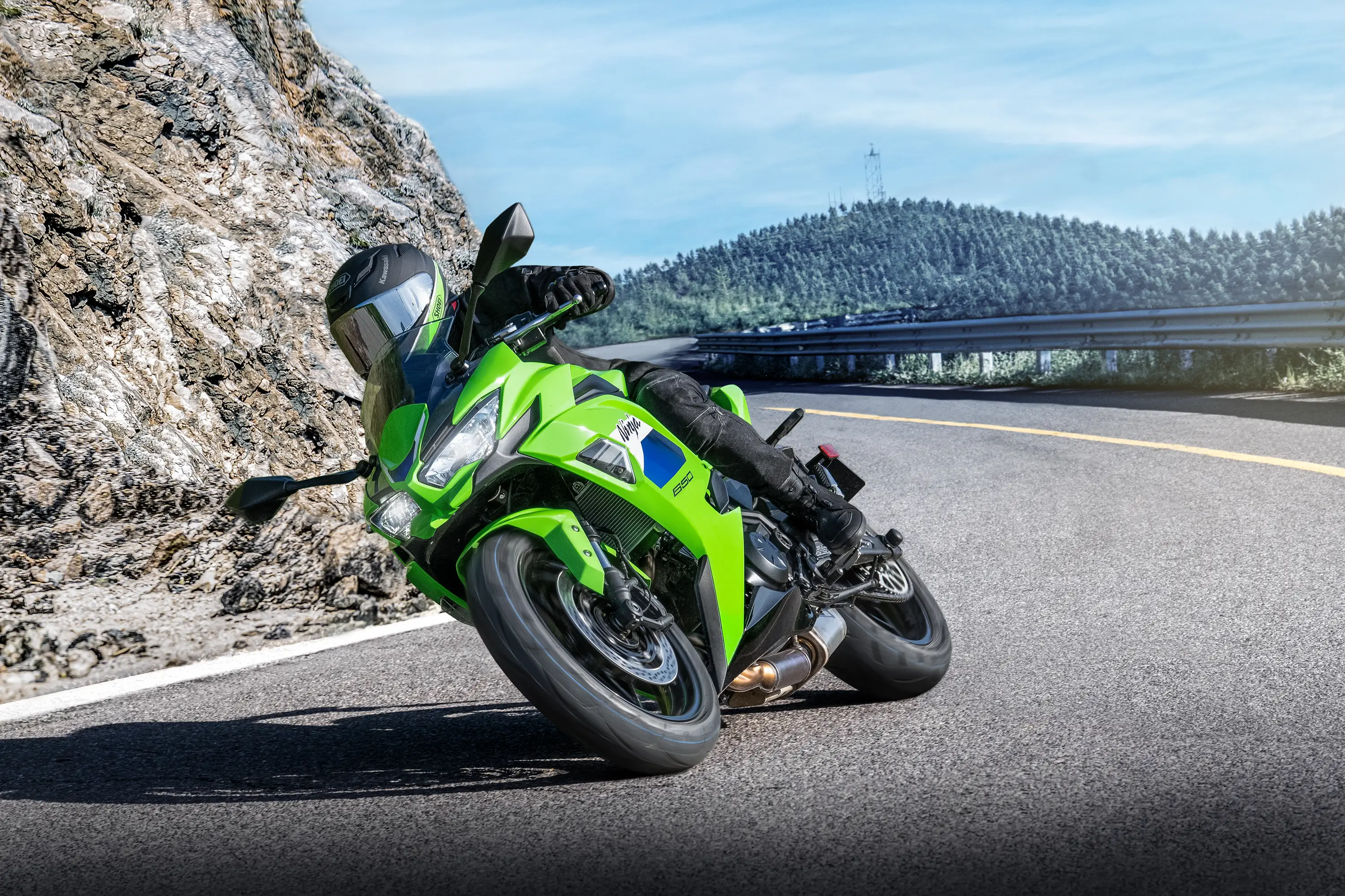 Three-quarter front angle of a person in a motorcycle turning on a highway.