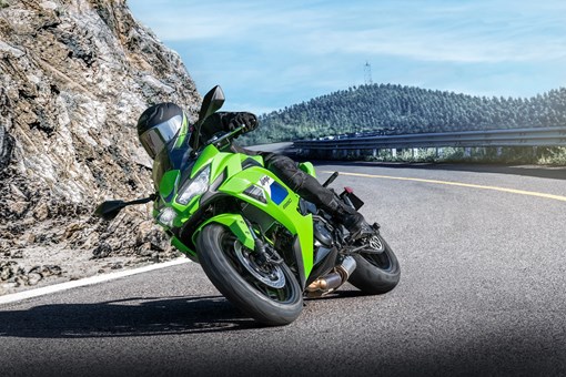Three-quarter front angle of a person in a motorcycle turning on a highway. opens in a new window