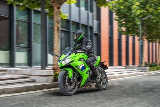 Front three-quarter angle of a person riding a motorcycle on the street. opens in a new window