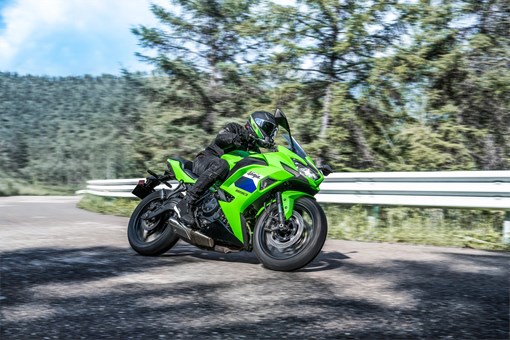 Front three-quarter angle of a person riding a motorcycle on a highway. opens in a new window