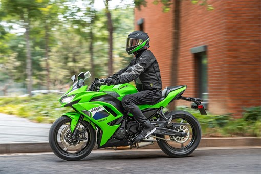 Profile angle of a person riding a motorcycle on the street. opens in a new window