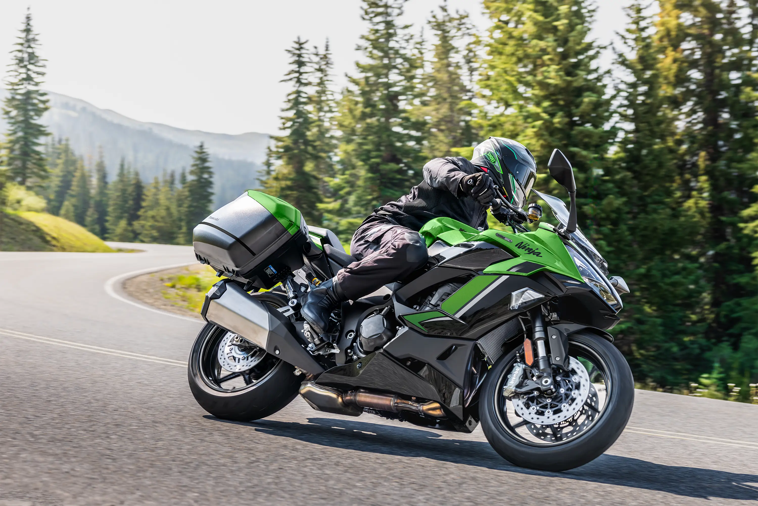 Side angle of a person riding a motorcycle on a highway.