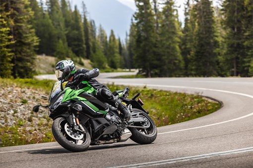 Three-quarter front angle of a person riding a motorcycle on a highway. opens in a new window