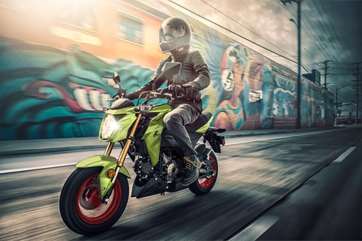 Three-quarter front angle of a person riding a motorcycle on the street. opens in a new window