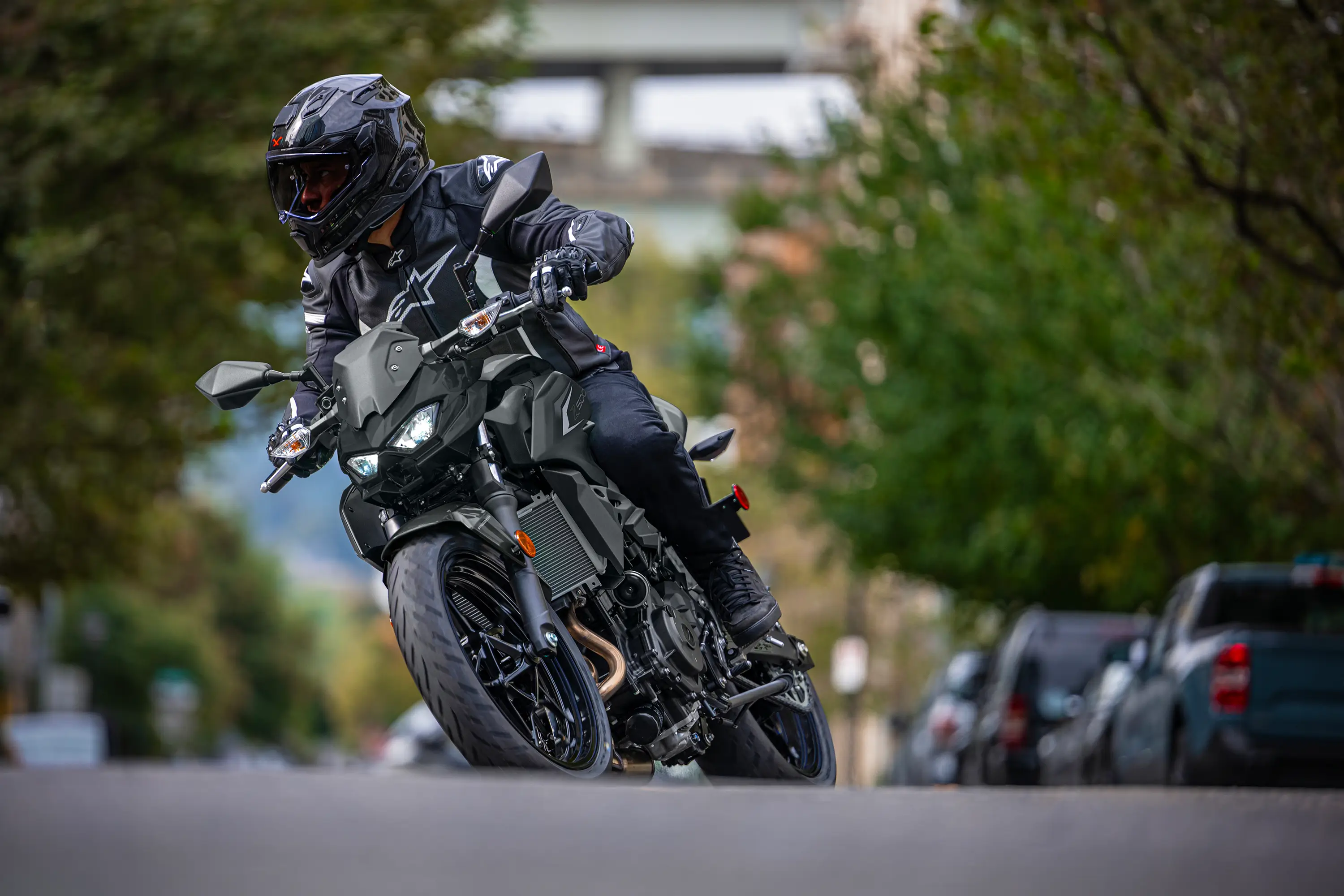Front angle low down of a person riding a motorcycle on the street.
