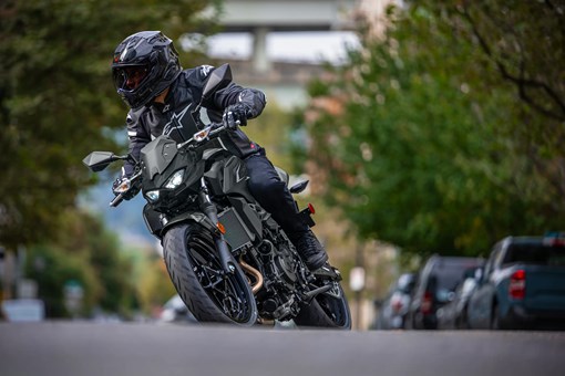 Front angle low down of a person riding a motorcycle on the street. opens in a new window