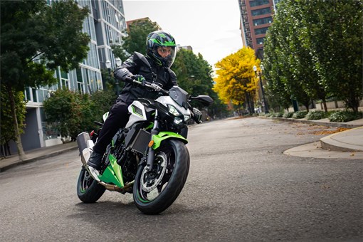 Three-quarter front angle of a person riding a motorcycle on the street. opens in a new window