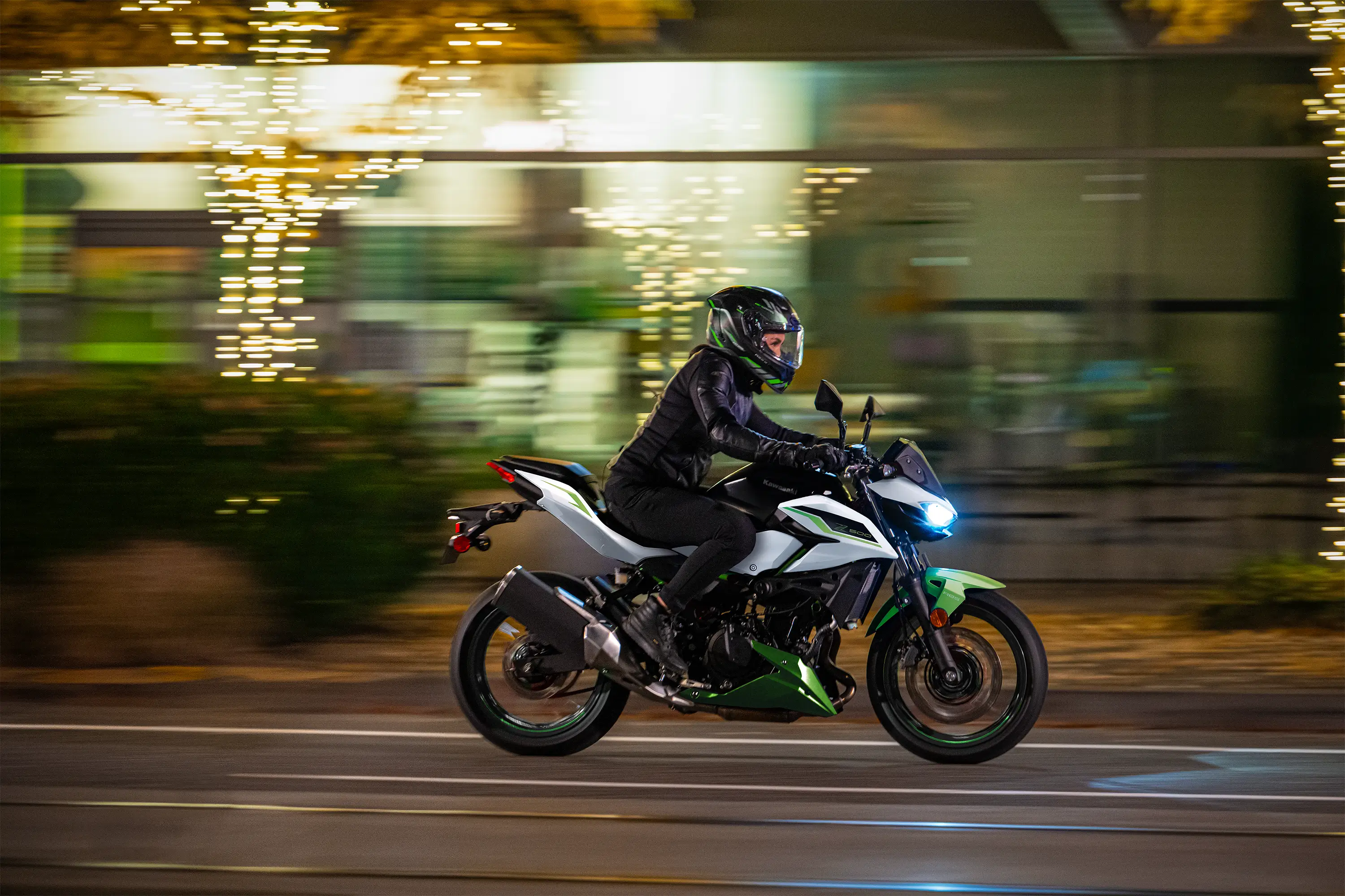Side angle of a person riding a motorcycle on the street.