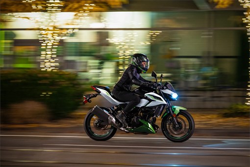 Side angle of a person riding a motorcycle on the street. opens in a new window