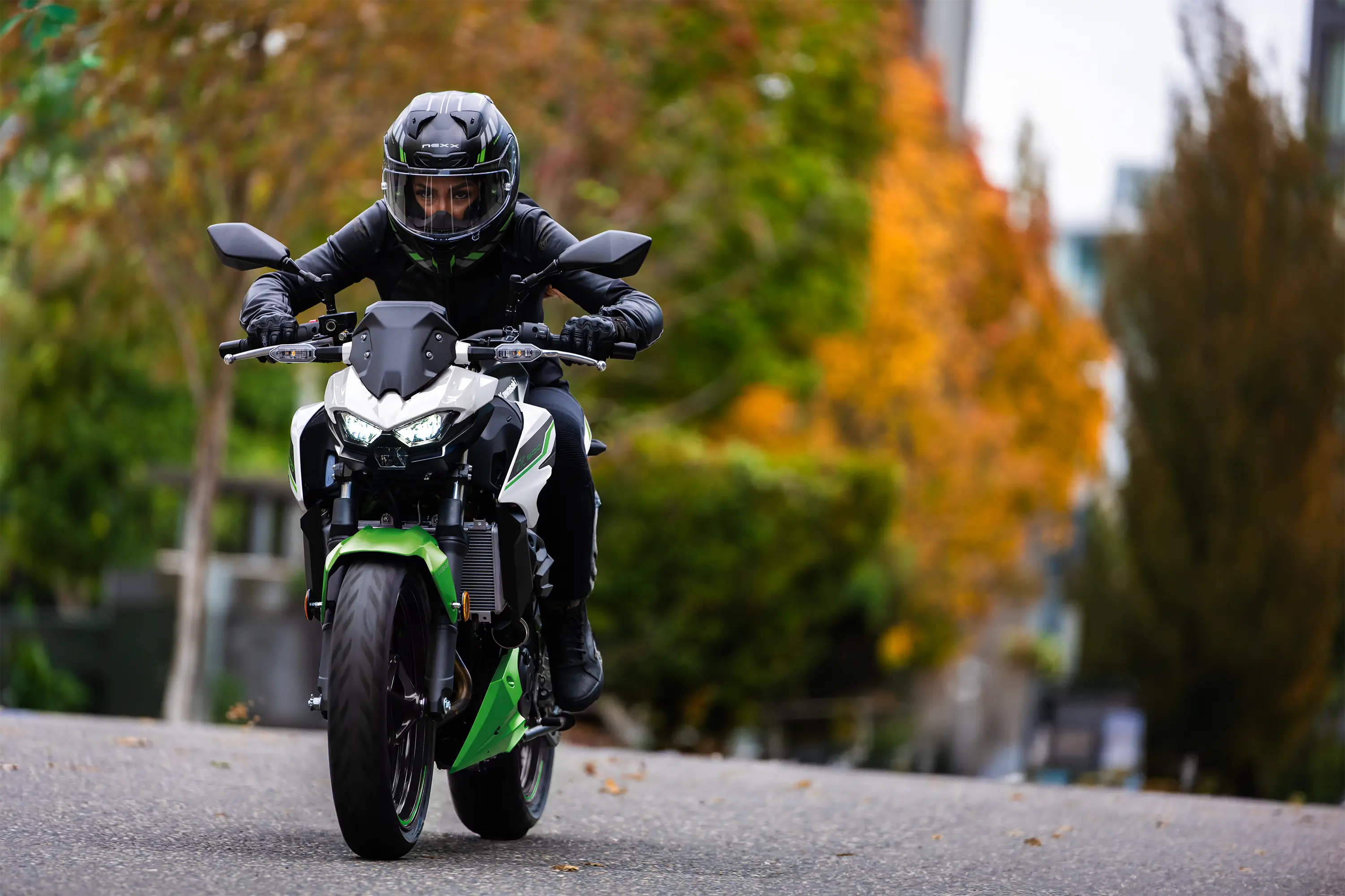 Front angle of a person riding a motorcycle on the street.