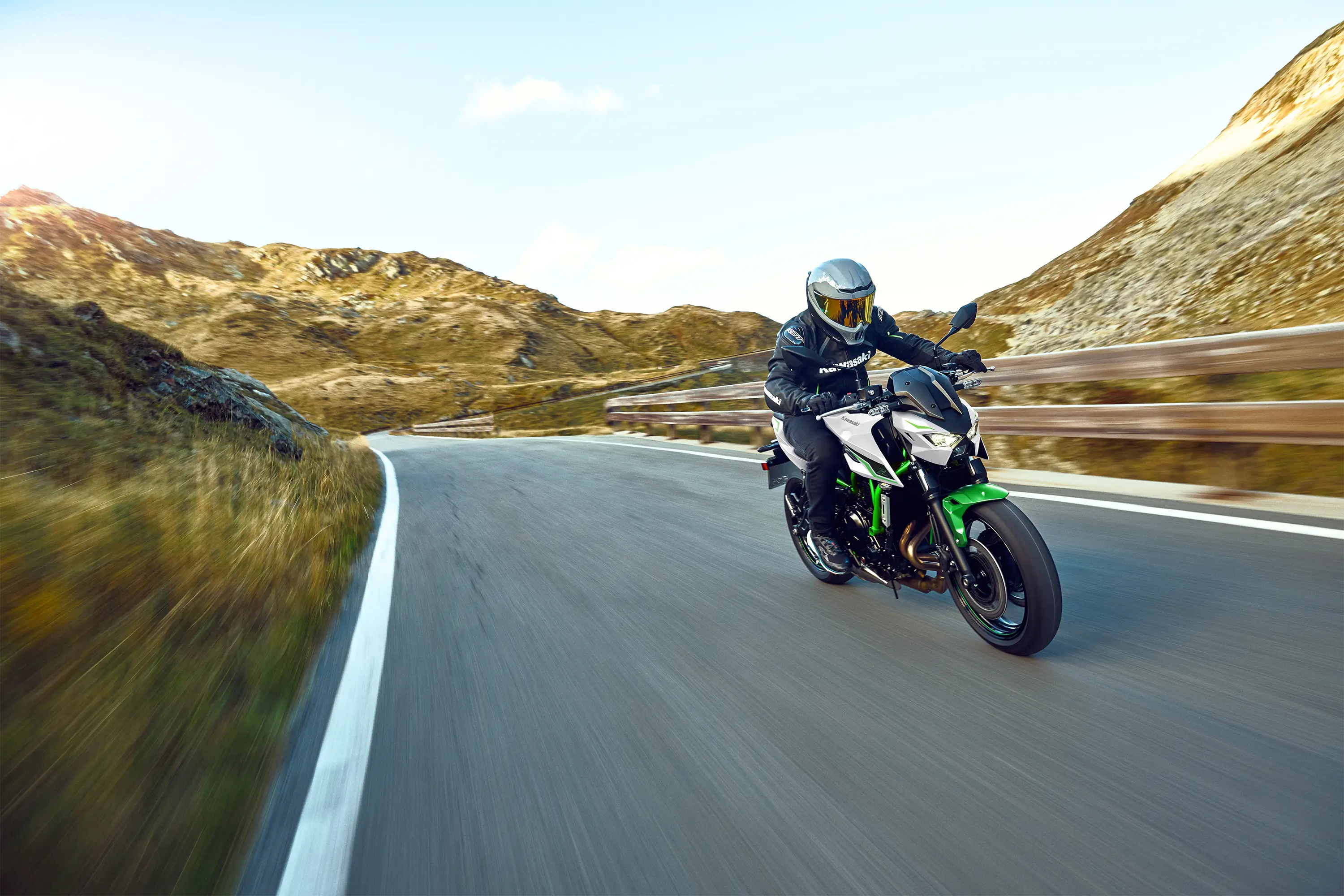 Three-quarter front angle of a person riding a motorcycle on a highway.