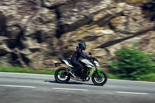 Side angle of a person riding a motorcycle on a highway. opens in a new window