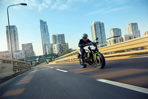Three-quarter front angle of a person riding a motorcycle on a city highway. opens in a new window