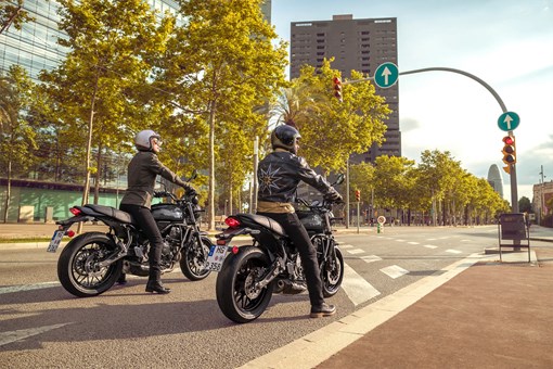 Rear angle of people riding a motorcycle on the street. opens in a new window