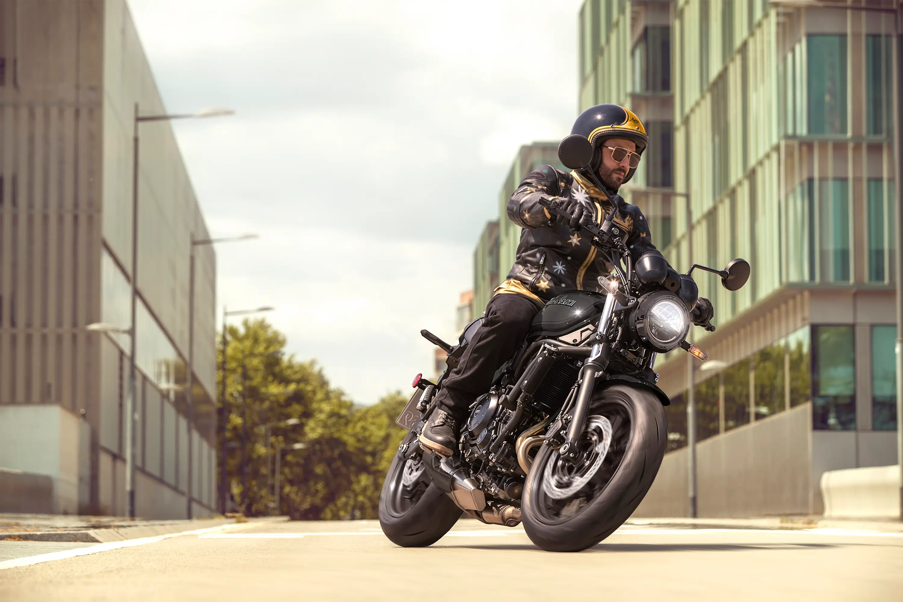 Three-quarter front angle of a person riding a motorcycle on the street.