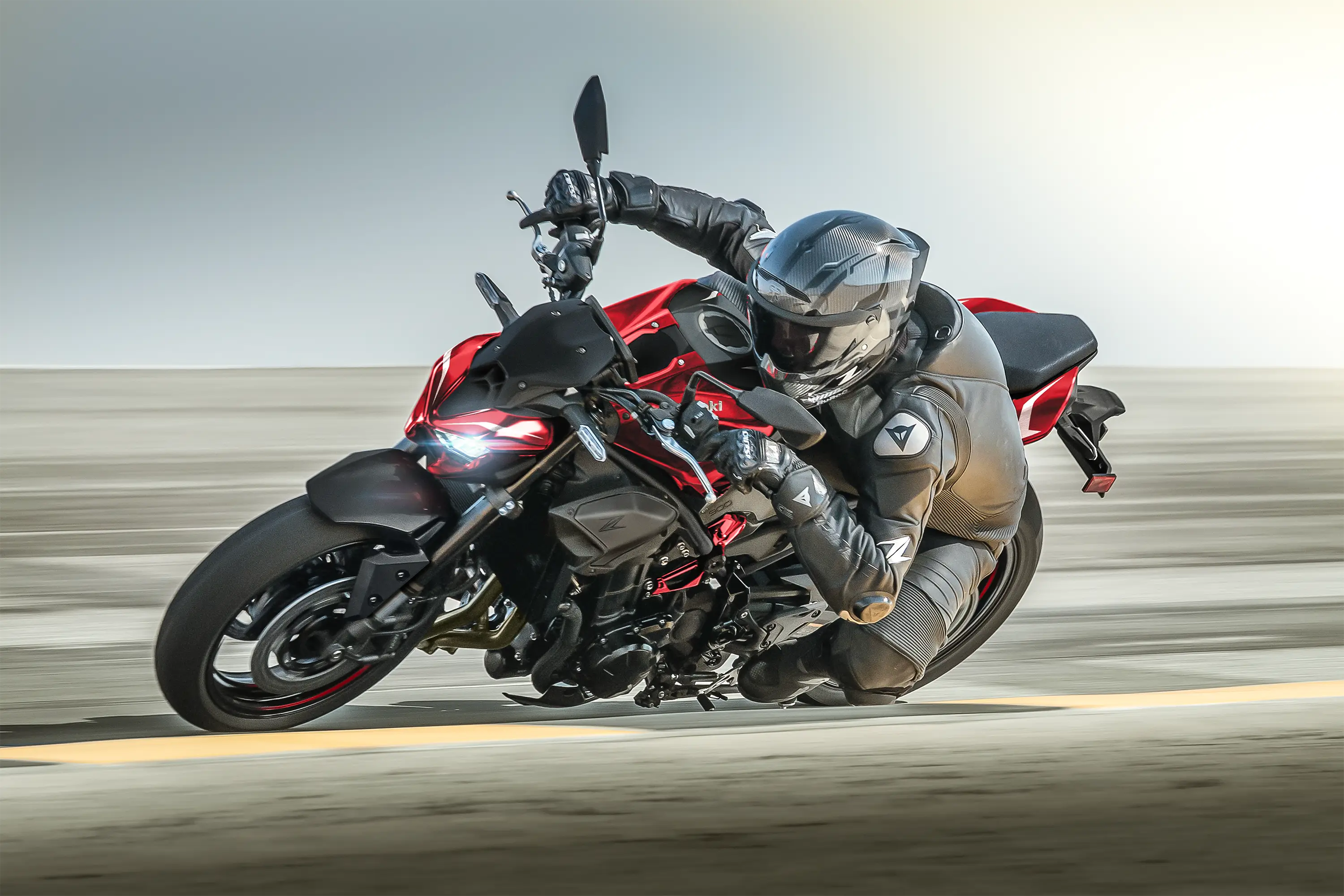 Side angle of a person aggressively turning a motorcycle on the street.